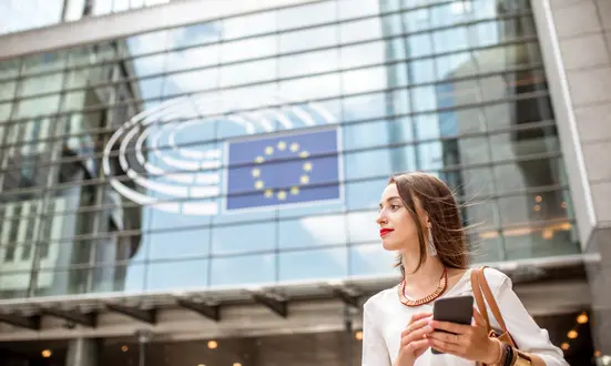 Frau mit Smartphone vor dem EU-Parlament – Datenschutz und DSGVO-Bewusstsein