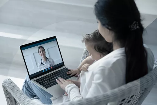 Mutter mit Kind bei einer Online-Beratung mit einer Ärztin.