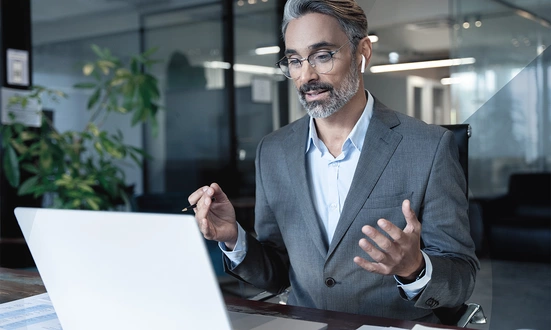 Businessman in a modern office conducting an online consultation with a client about financial services