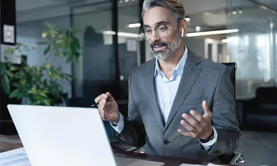 Geschäftsmann in einem modernen Büro bei einer Online-Beratung mit einem Kunden zu Finanzdienstleistungen