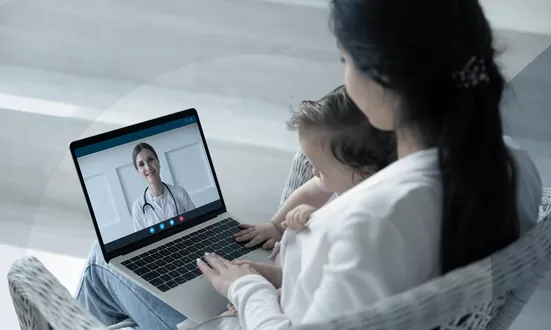 Mother with child in an online consultation with a doctor